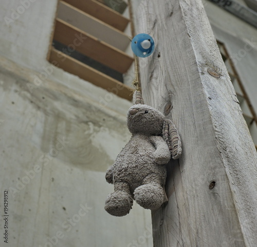 Doudou et tétine perdus accrochés au mur dans la rue. photo