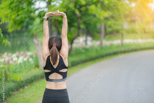 Fitness pretty asia woman stretching hands outdoors