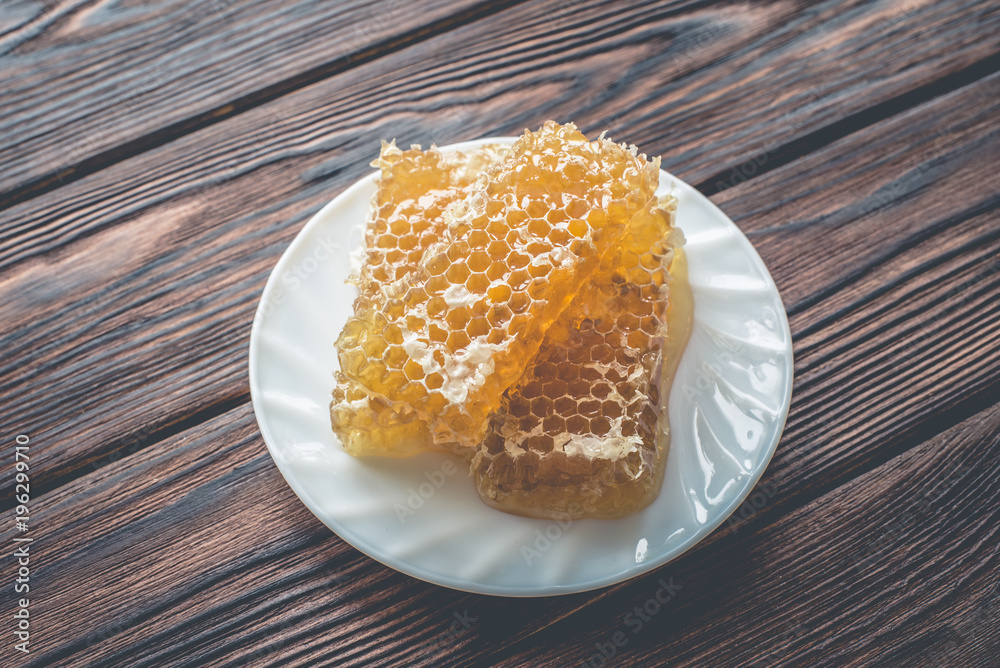 honey in honeycombs on a white plate honey in honeycombs on a white plate