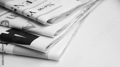 News in headlines of daily papers. Folded newspapers for background