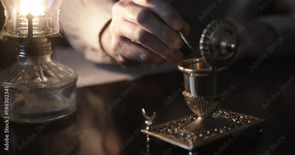 Scene tracks the action of the hand of a Caucasian male using a period appropriated vintage 1800s dip pen to write with.