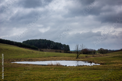 Fototapeta Naklejka Na Ścianę i Meble -  Landscape with meadow at cloudy day near Bunelka mountain, Masuria, Poland