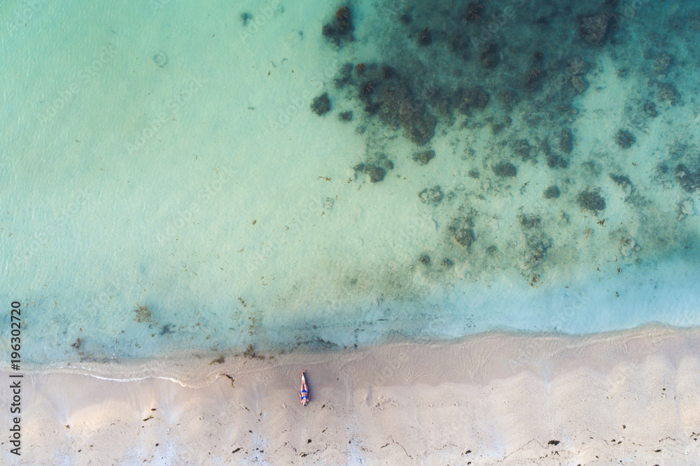 aerial drone view of beautiful, young woman with blue bikini on a great beach in thailand, koh samui