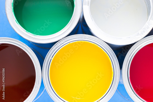 House renovation, paint cans on blue background top view