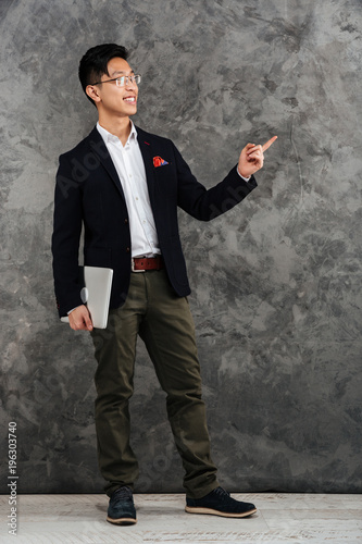 Full length portrait of a happy young asian man