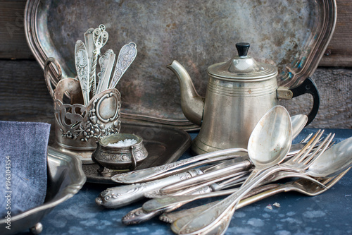 Vintage old utensils made of nickel silver, tableware (kettle, teaspoons, tablespoons, knives, forks, tray, dish), horizontal, space for text
