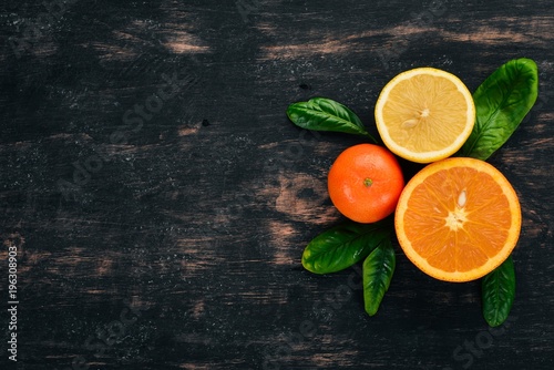 A set of citrus fruit. Orange, tangerine, grapefruit, lemon. On a wooden background. Top view. Copy space. © Yaruniv-Studio