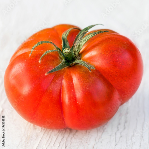 Single  big tomato  on  old wooden table, copyspace. Huge Beefsteak tomato kind for cooking. Food organic concept. photo