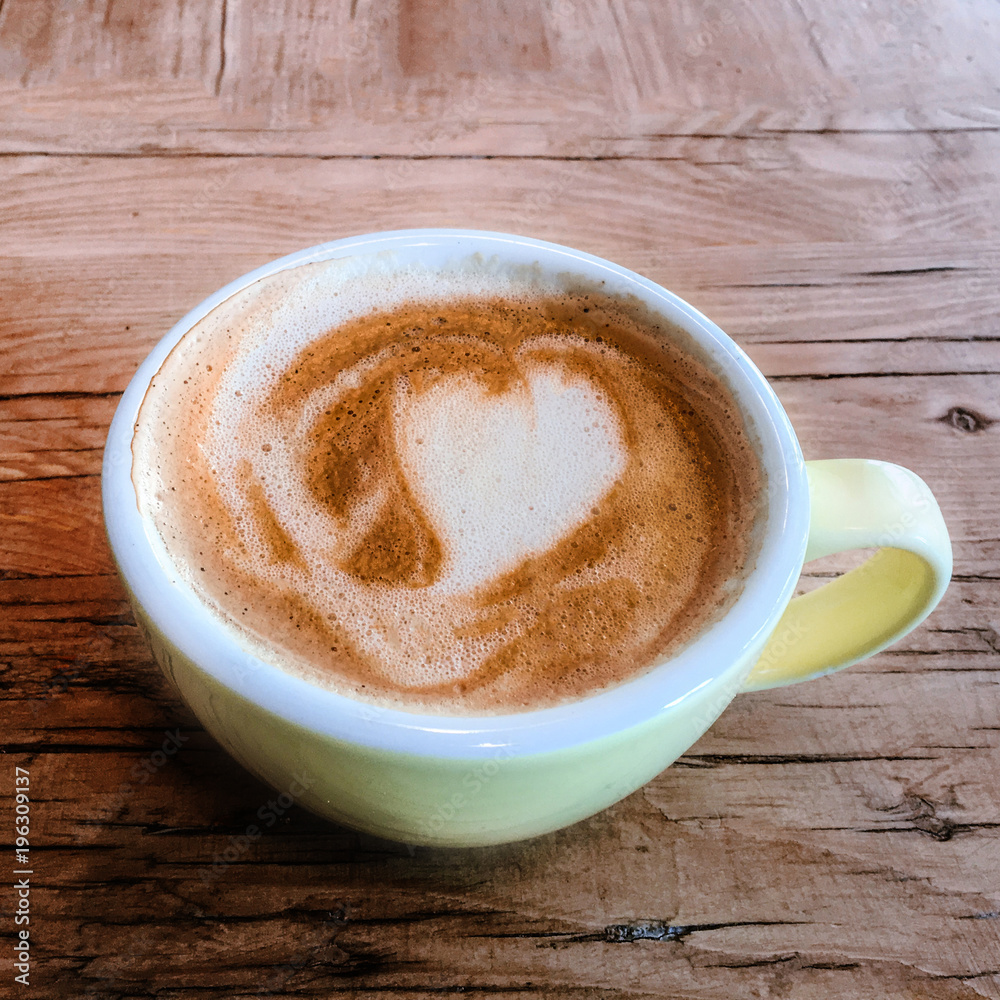 Cup of coffee in a colourful cup on rustic wooden table Cup of coffee in a colourful cup on rustic wooden table