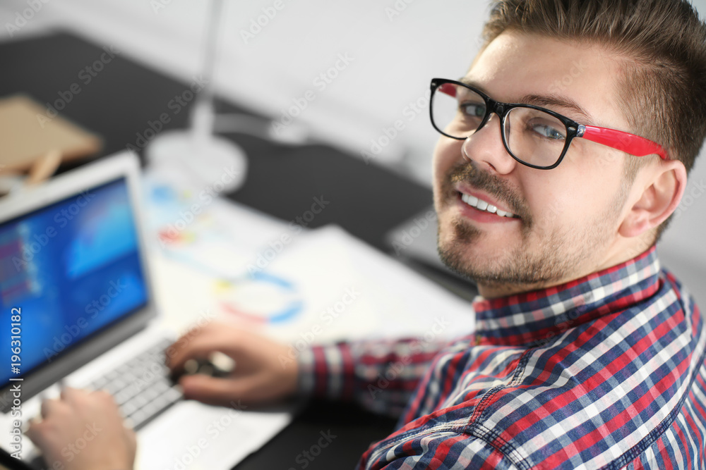 Young man with laptop working in office Young man with laptop working in office