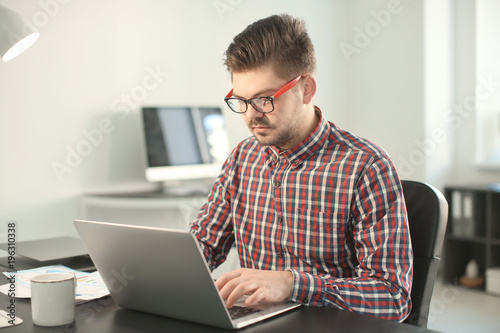 Young man with laptop worki...