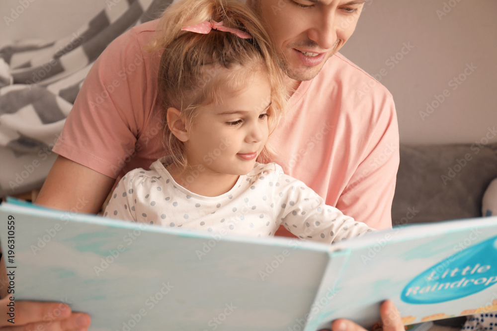 Father and his daughter reading book on floor in children room Father and his daughter reading book on floor in children room