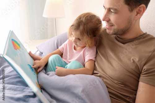 Obraz na plátně Father with little daughter reading bedtime story at home