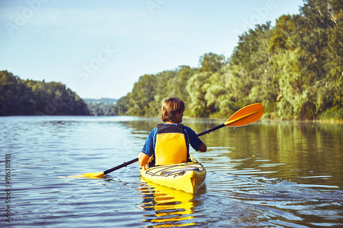A canoe trip along the river along the forest in summer. photo