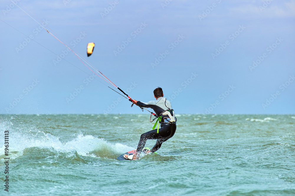 Man riding a kite surfing on the waves in the summer. Man riding a kite surfing on the waves in the summer.
