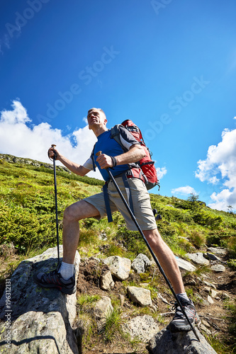 Hiking in the mountains in the summer with a backpack.