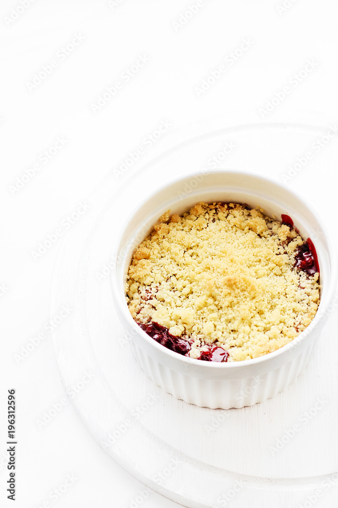 Cherry crumble in a white form on a white background. Food concept Cherry crumble in a white form on a white background. Food concept