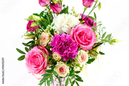 Composition of flowers in a pink hatbox. Tied with wide white ribbon and bow