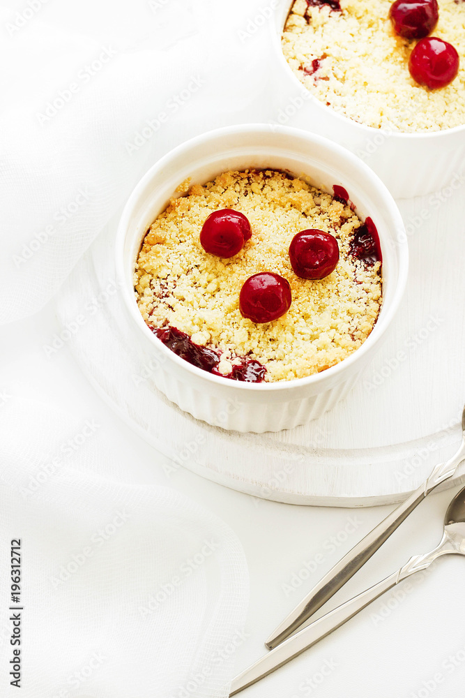 Cherry crumble in a white form on a white background. Food concept Cherry crumble in a white form on a white background. Food concept