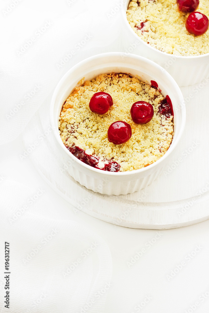 Cherry crumble in a white form on a white background. Food concept Cherry crumble in a white form on a white background. Food concept