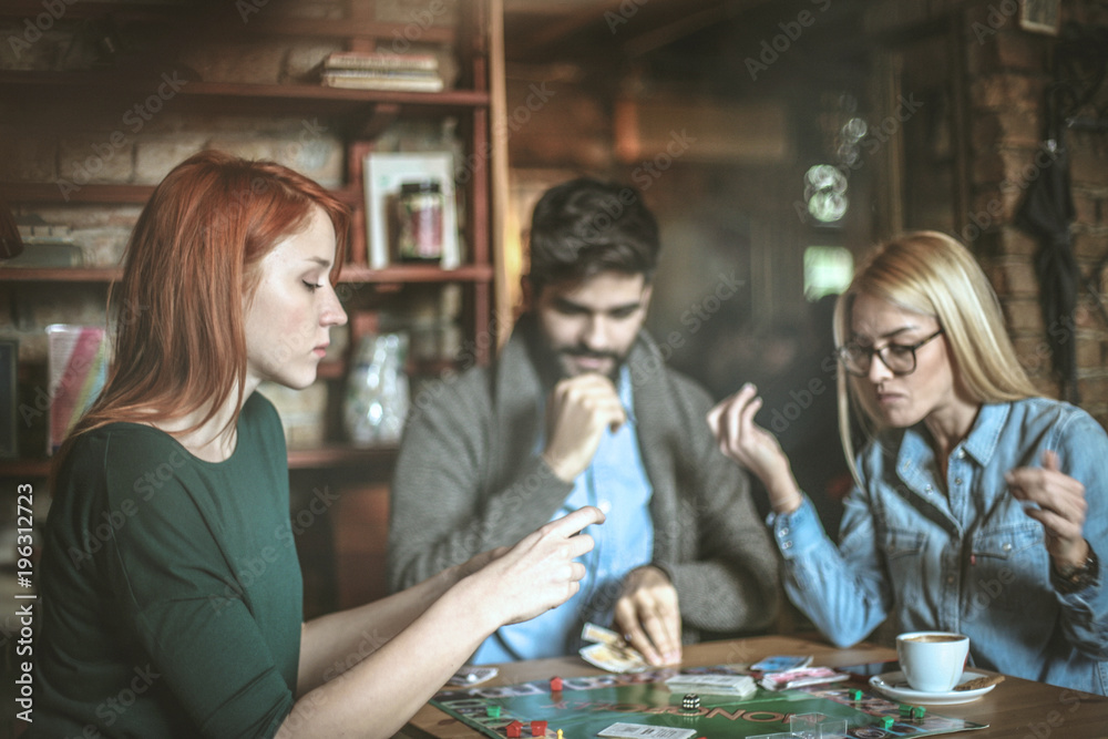 Fototapeta premium Friends at cafe playing leisure game.