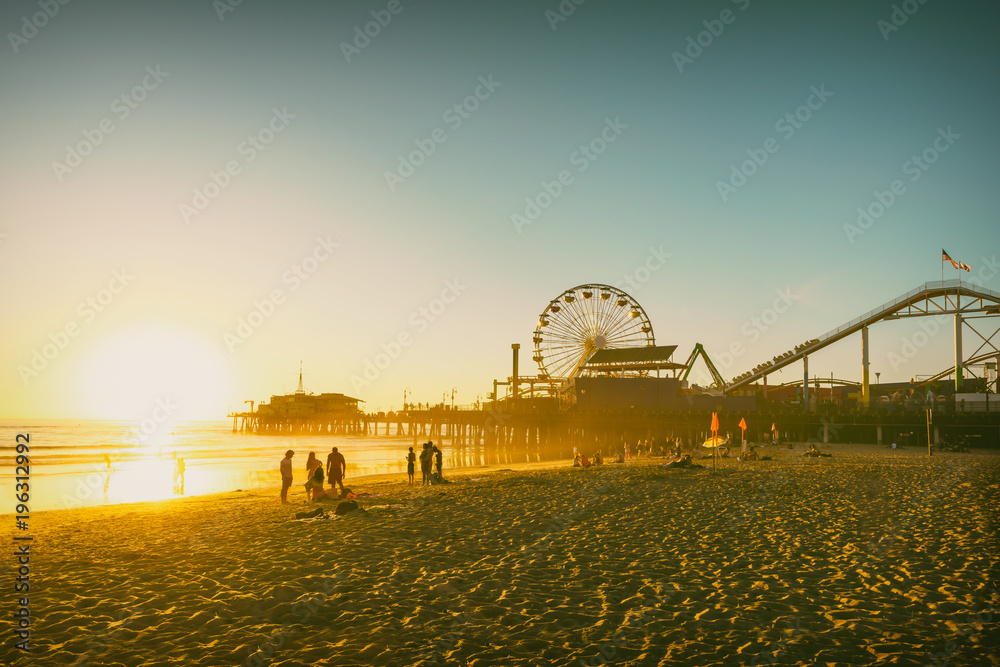 Fototapeta premium Molo na plaży w Santa Monica w Kalifornii w USA o zachodzie słońca. Kolory retro