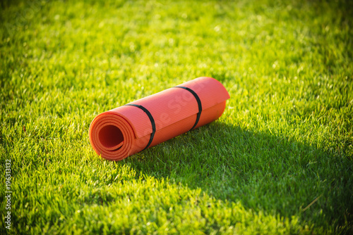 Yoga mat on green grass, fitness