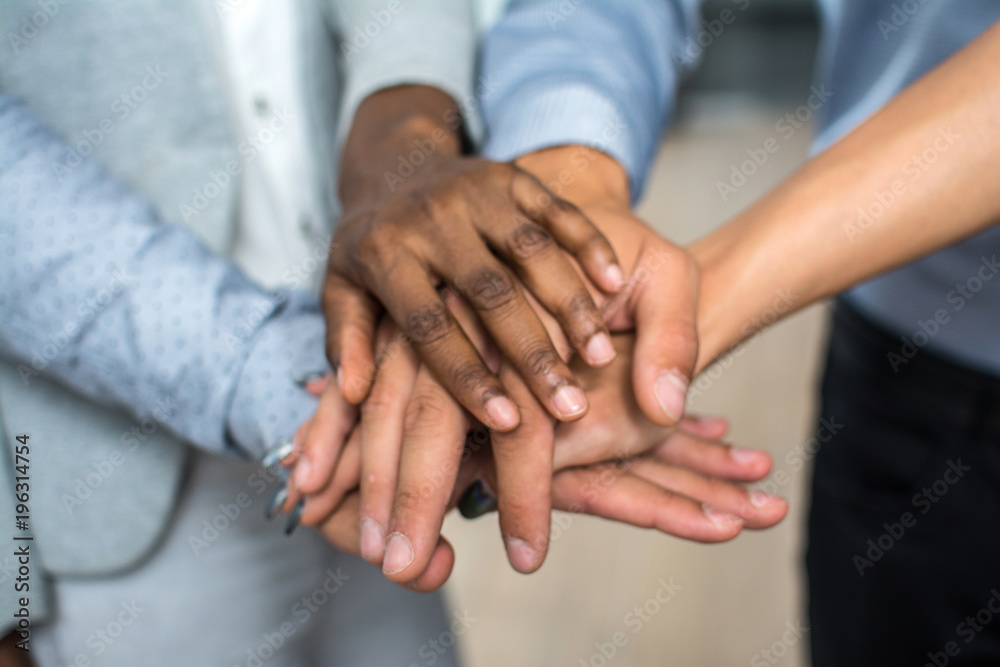 Multiracial business people stacking hands over each other Multiracial business people stacking hands over each other