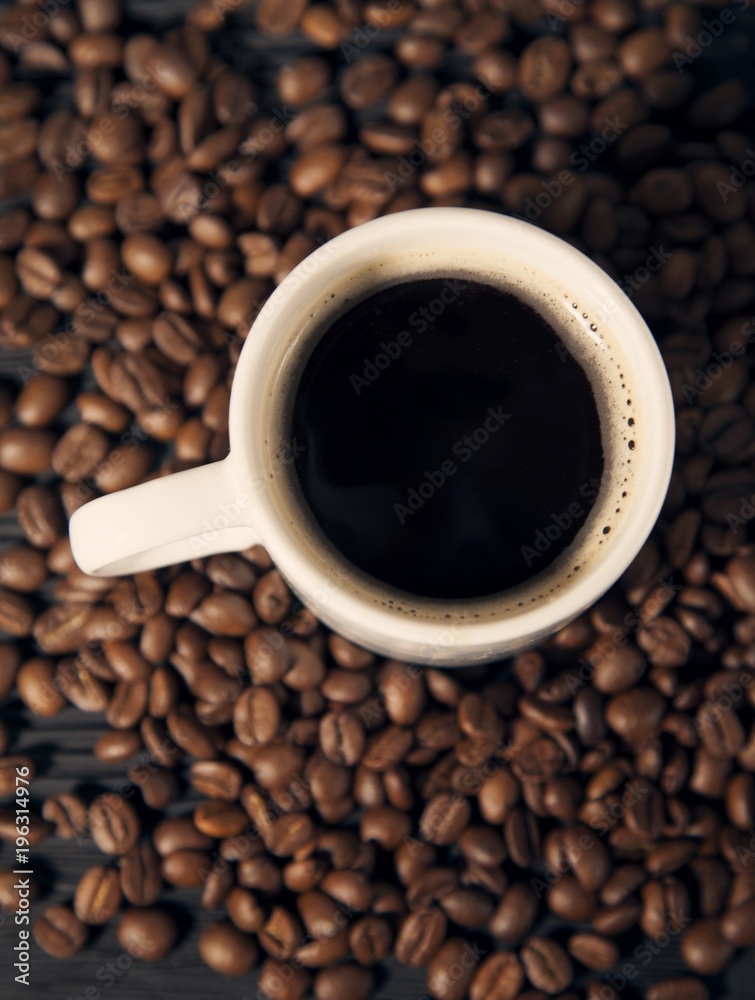 coffee beans and cup on a black old wooden bg top view