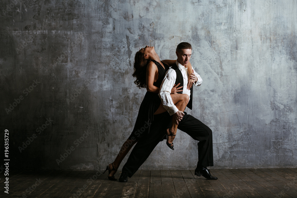 Young pretty woman in black dress and man dance tango - obrazy, fototapety, plakaty 