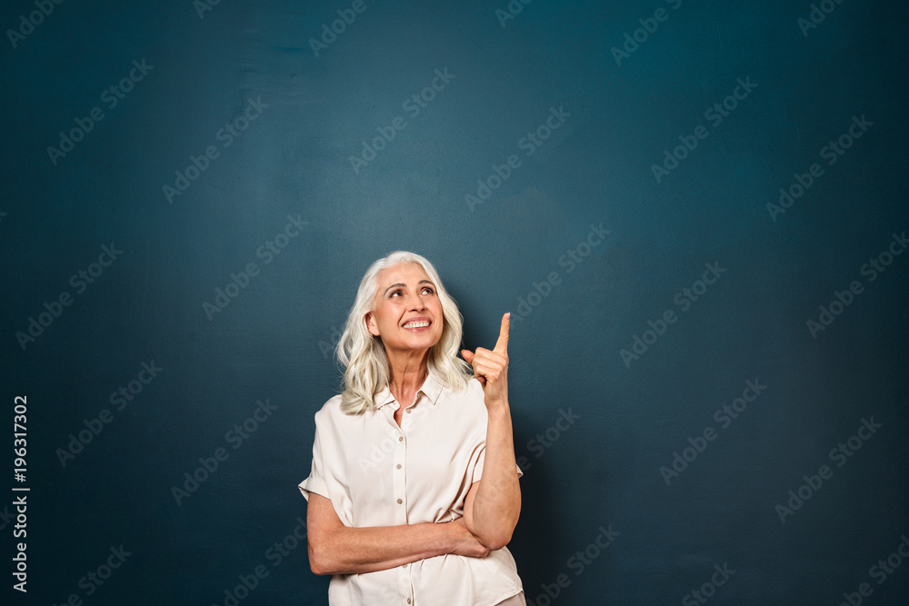 Mature old beautiful woman pointing showing copyspace