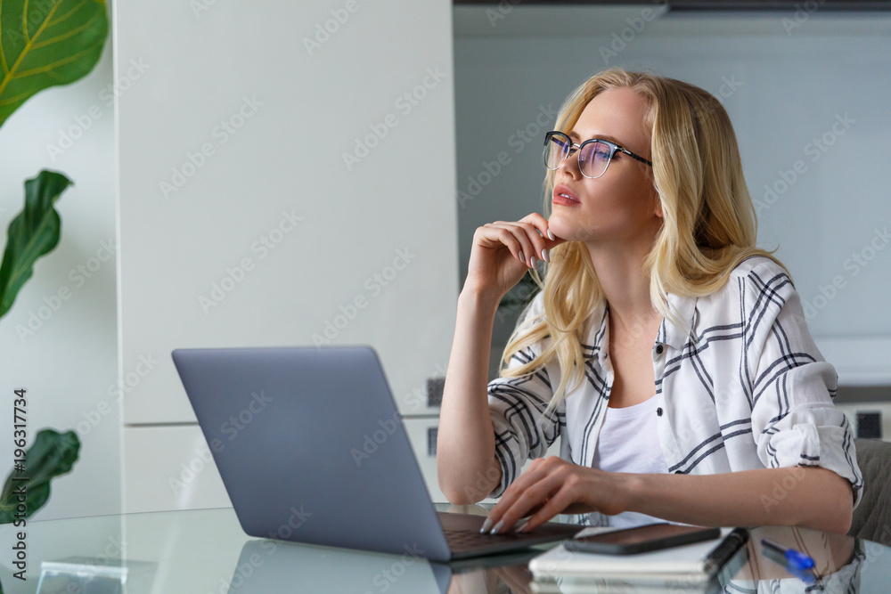 beautiful pensive blonde woman using laptop while working at home beautiful pensive blonde woman using laptop while working at home