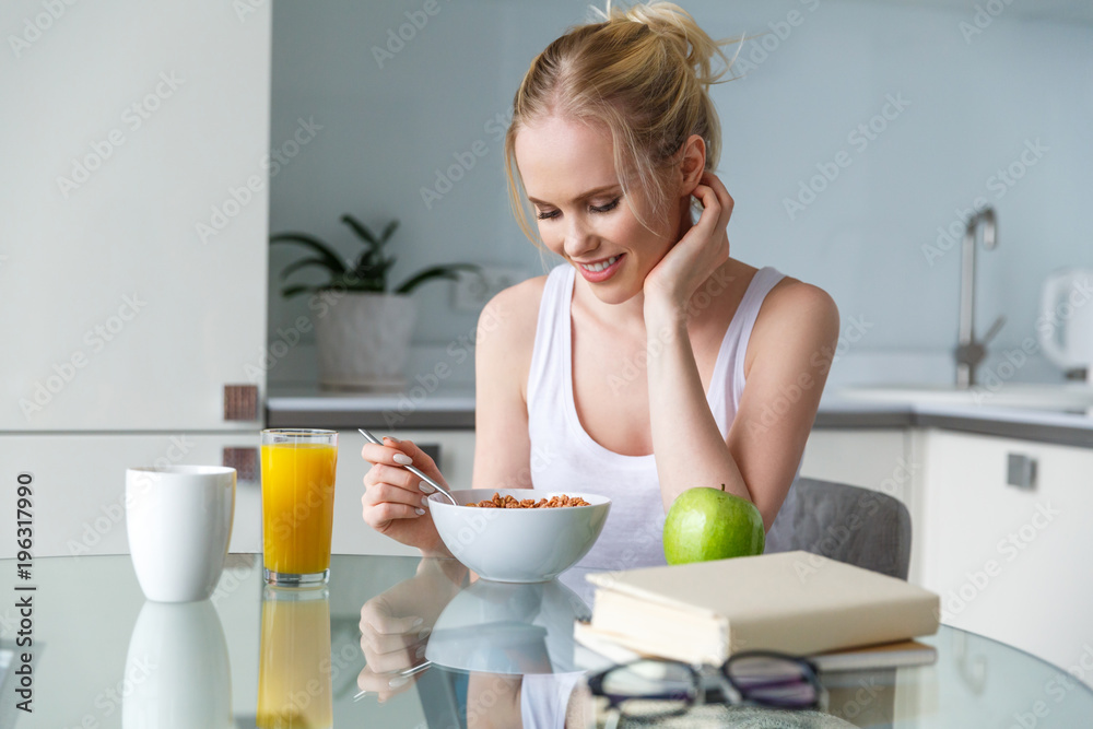 beautiful smiling young woman eating muesli for breakfast at home beautiful smiling young woman eating muesli for breakfast at home