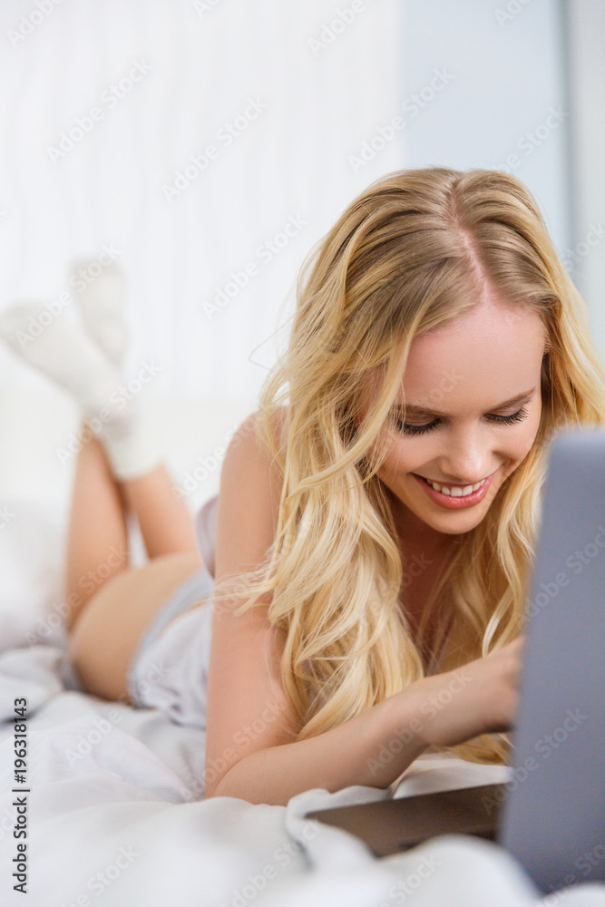 beautiful happy blonde girl using laptop on bed beautiful happy blonde girl using laptop on bed