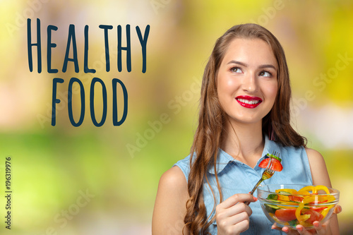 Smiling woman holding glass bowl with salad.