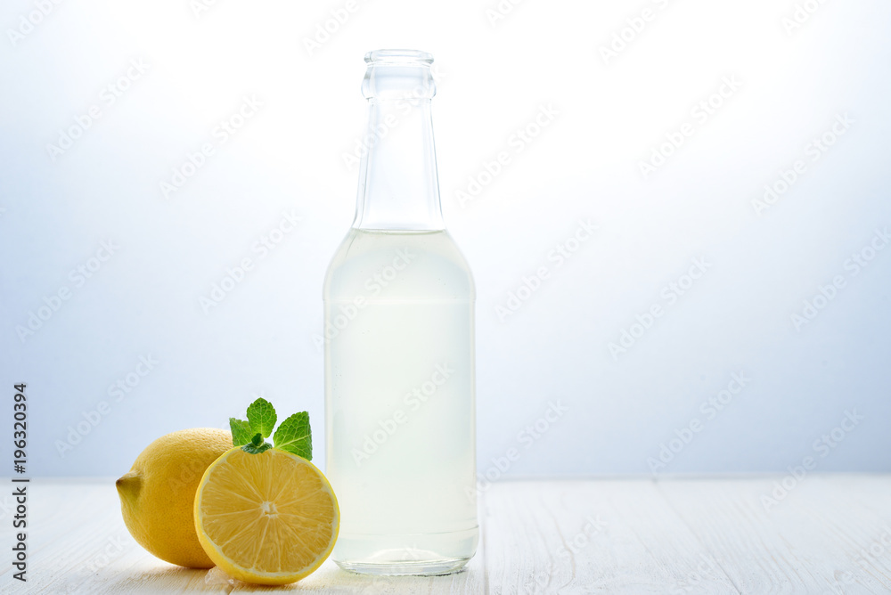 Citrus lemonade water with lemon sliced , healthy and detox water drink in summer on white wooden table with apple, oranges and lemons. Citrus lemonade water with lemon sliced , healthy and detox water drink in summer on white wooden table with apple, oranges and lemons.
