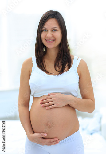 portrait of young pregnant woman on a light background. Free Download portrait of young pregnant woman on a light background. - GFXLoad