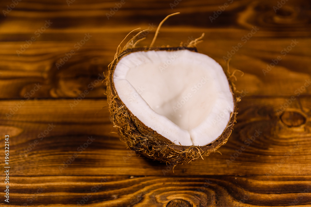 Ripe halved coconut on a wooden table Ripe halved coconut on a wooden table