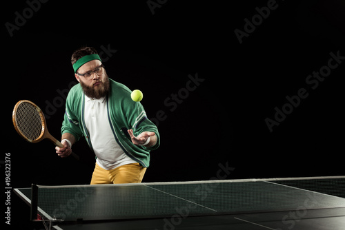 bearded tennis player practicing in tennis isolated on black © LIGHTFIELD STUDIOS