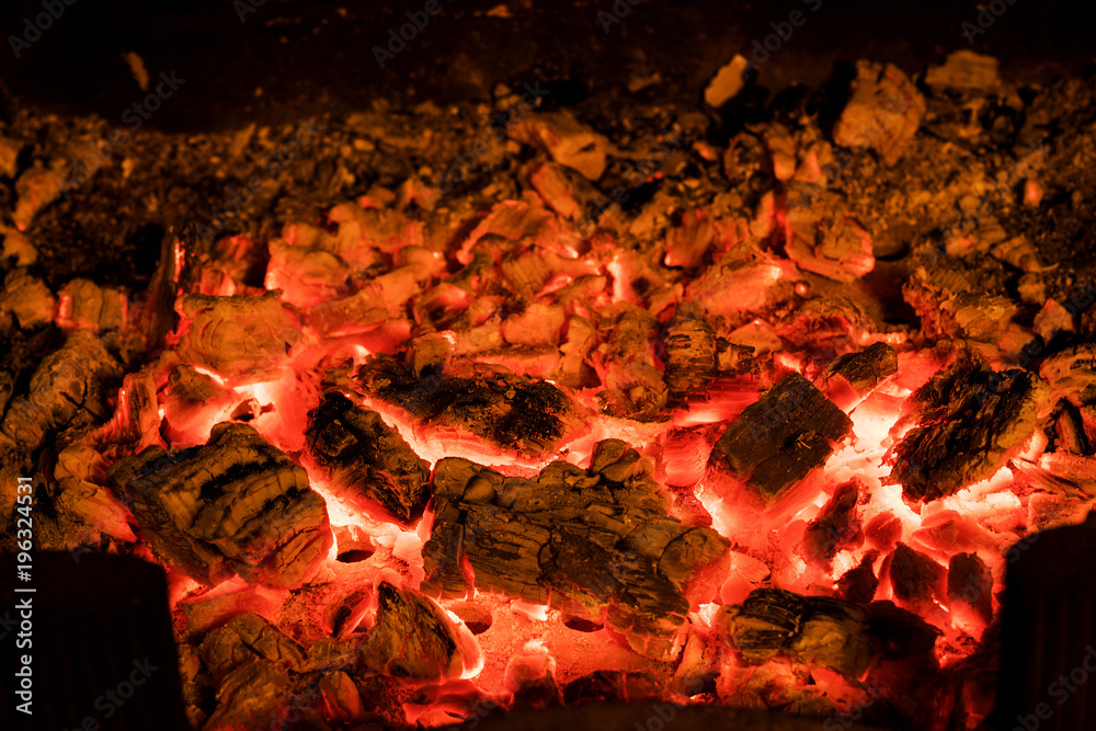 Photo of hot sparking live-coals burning in a barbecue. Photo of hot sparking live-coals burning in a barbecue.