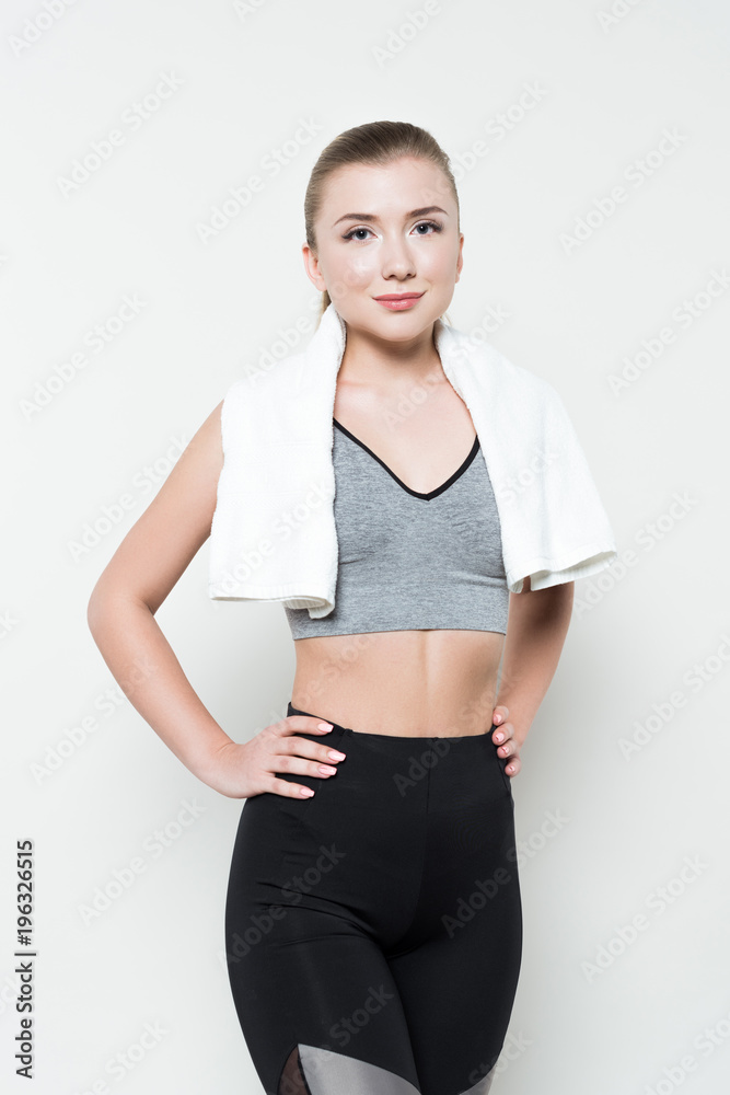 Smiling sportswoman with towel on shoulders isolated on white Smiling sportswoman with towel on shoulders isolated on white