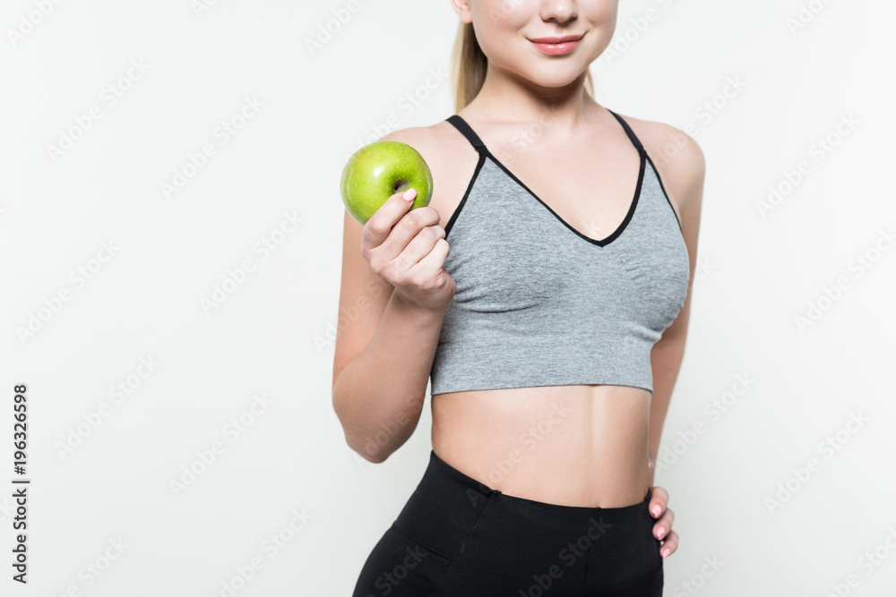 Cropped view of sportive girl holding apple isolated on white Cropped view of sportive girl holding apple isolated on white