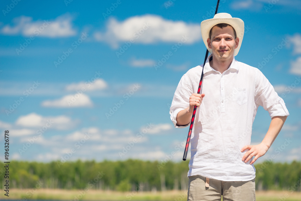 horizontal portrait of a fisherman with a fishing rod in nature on a sunny day