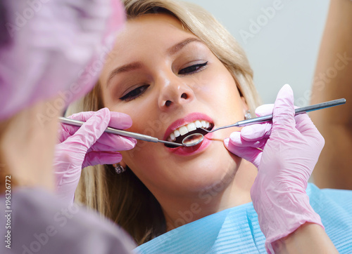 Young dentist working in dental clinic with patient in the chair