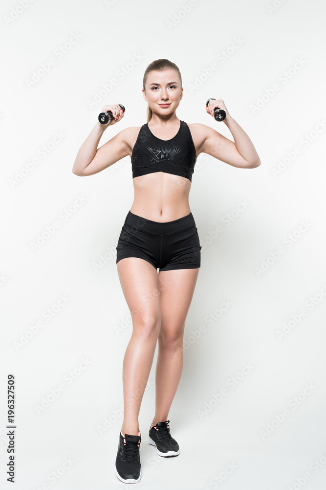 Sportive woman training with dumbbells isolated on white