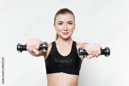 Sportive woman exercising with dumbbells isolated on white