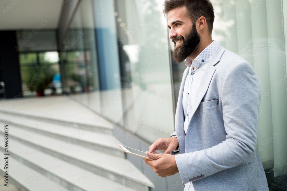 Shot of smiling businessman sitting on bench with digital tablet Shot of smiling businessman sitting on bench with digital tablet