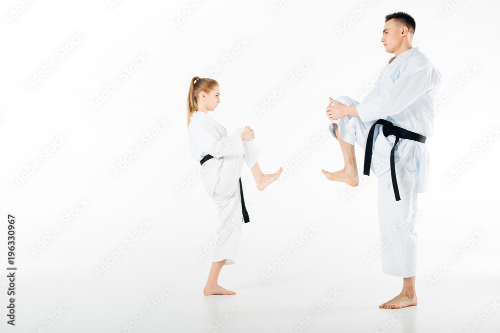 Side view of karate fighters stretching legs isolated on white
