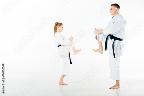 Side view of karate fighters stretching legs isolated on white