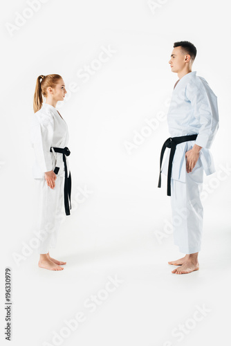 karate fighters standing and looking at each other isolated on white